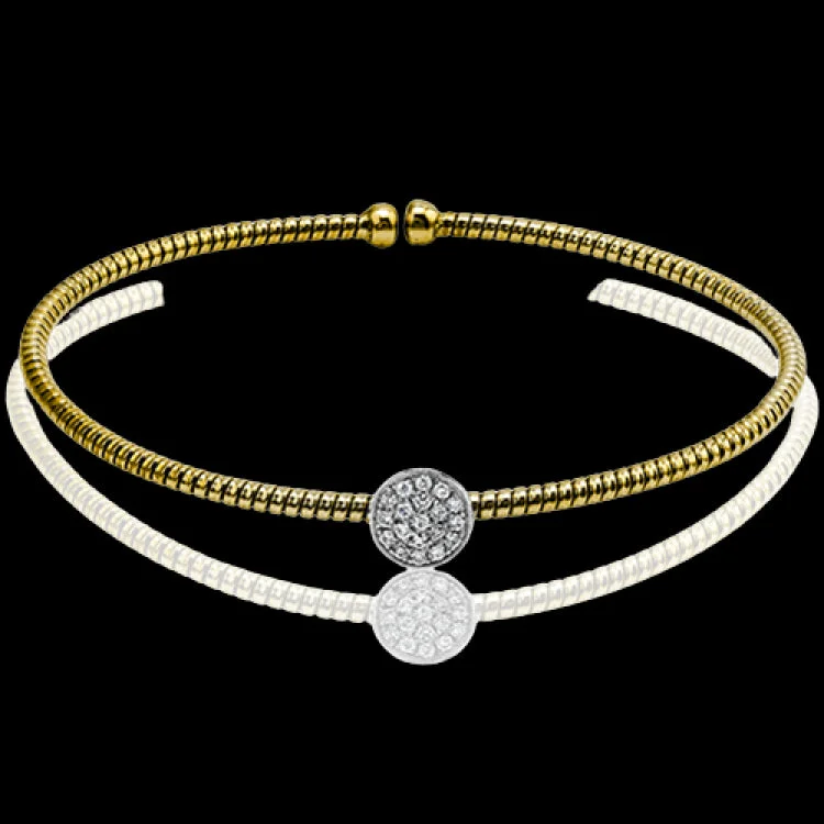 Women’s bangle bracelets-This elegant modern white and yellow gold bangle style bracelet features a lovely circular setting accented with .15 ctw of round cut white diamonds.